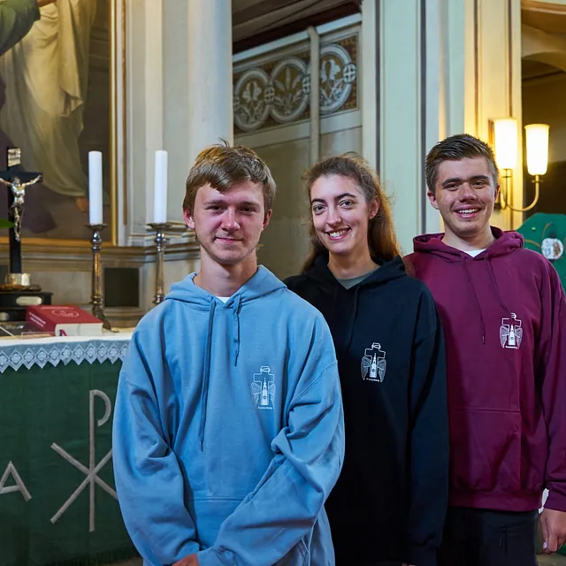 Mitglieder der Jungen Gemeinde stehen vor dem Altar und freue