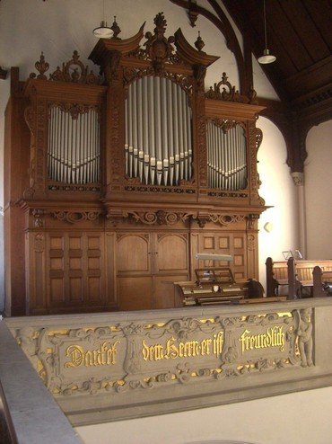 Orgel Hohenfichte hinter der Empore, auf der "Danket dem Herrn, er ist freundlich." geschrieben ist.