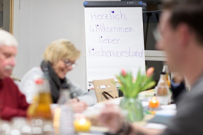 Menschen sitzen um einen Tisch und beraten