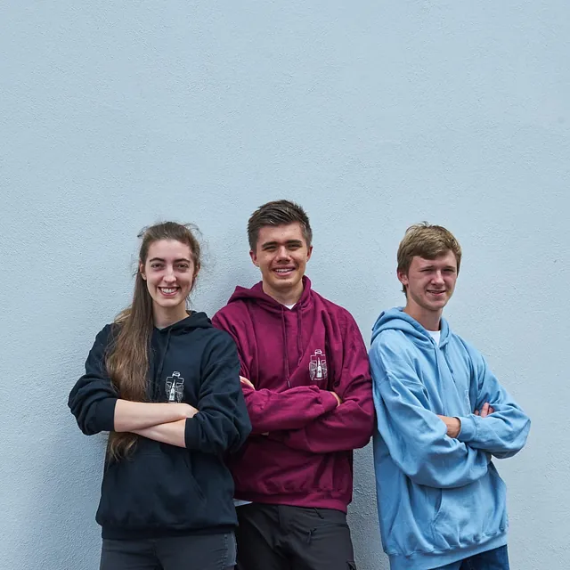 Mitglieder der Jungen Gemeinde stehen vor der Kirche und freue