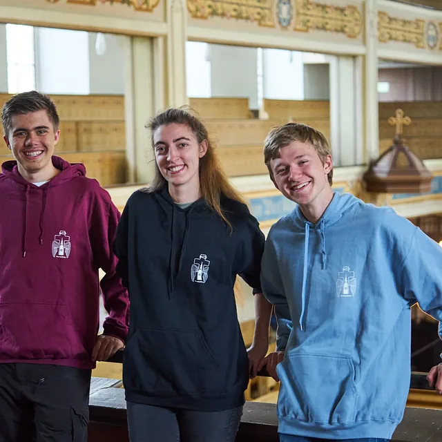 Mitglieder der Jungen Gemeinde stehen auf der Empore und freuen sich