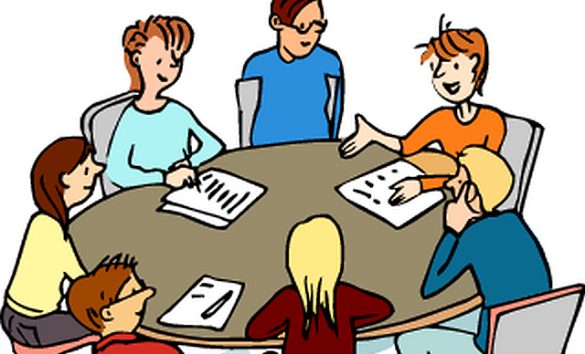 Menschen sitzen um einen Tisch und beraten