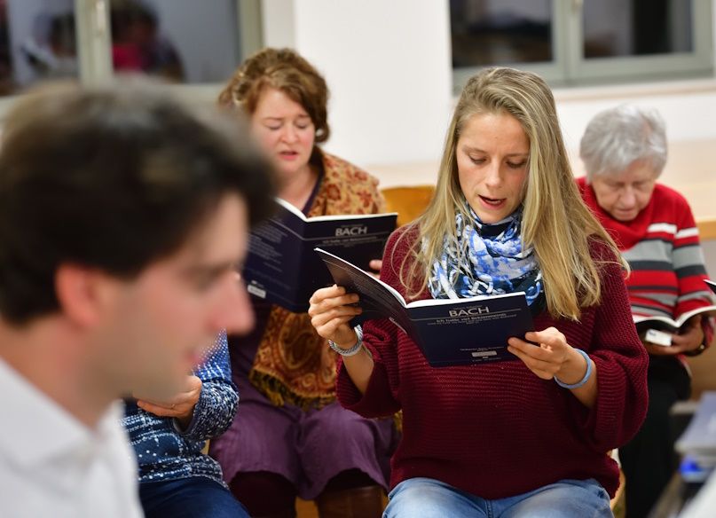 Kirchenchor-Mitglieder bei einer Gesangsprobe, fotografiert von vorne.