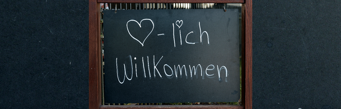 eine Tafel auf der "Herzliche Willkommen" steht