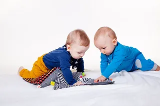 Zwei Babys spielen miteinander