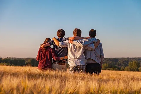 Symbolbild Konfi-Samstage - 4 Jugendliche Arm in Arm in einem Kornfeld